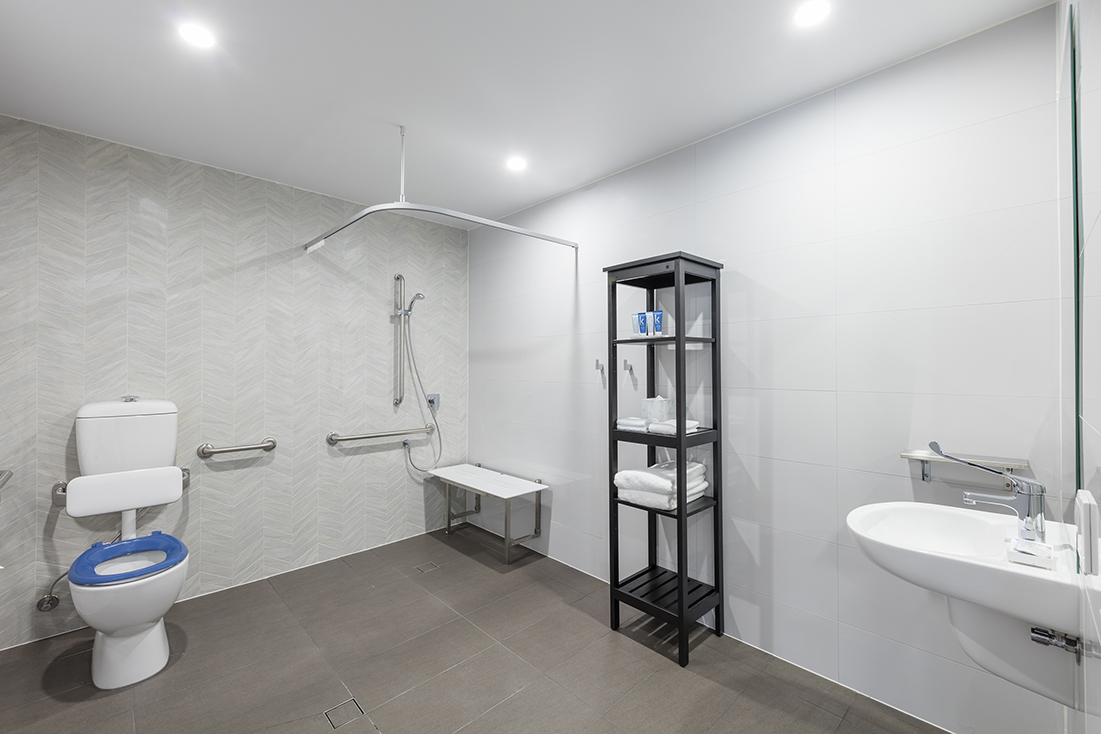 Accessible bathroom with grab rails and level-access shower